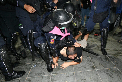 Police arrest a man during a protest at Sanam Luang on Mar. 20, 2021.