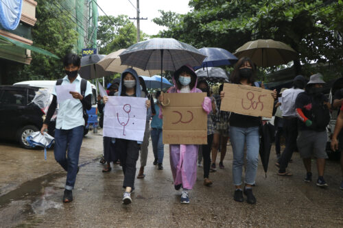 Anti-coup protesters hold slogans which read "Rain Strike" as they use their umbrellas during a drizzle while participating in a demonstration in Yangon, Myanmar on Tuesday April 6, 2021. Photo: AP