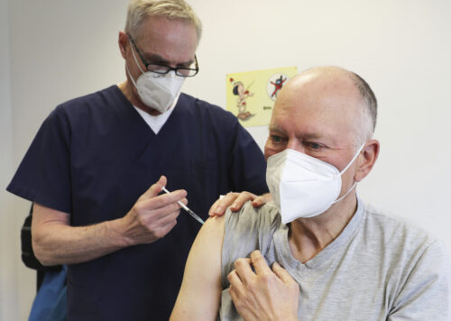 Manfred Haas, right, receives the AstraZeneca vaccine against the COVID-19 disease from his family doctor Oliver Funken in Rheinbach, Germany, Tuesday, April 6, 2021. Photo: Oliver Berg / dpa via AP