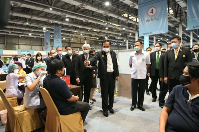 PM Prayut Chan-o-cha raises his thumb to a man who is receiving a COVID-19 vaccine at Central Plaza Ladprao mall on May 12, 2021.