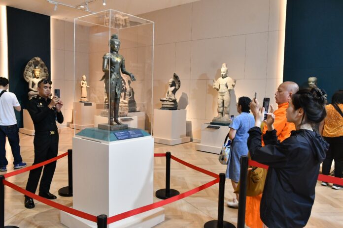 Visitors take photo of the Standing Shiva (also known as the Golden Boy statue) at the National Museum in Bangkok on May 23, 2024.